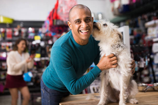 Portrait of man with beloved dog in pet shop Portrait of happy man with beloved dog in pet shop pet shop photos stock pictures, royalty-free photos & images
