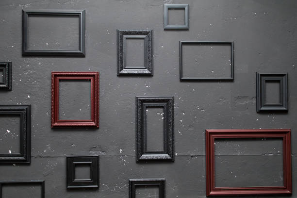 Variety of epty frames on a wall Photo frames on a stone wall. Dark room with different classic frameworks. Abstract loft home decor. multiple picture frames on wall stock pictures, royalty-free photos & images