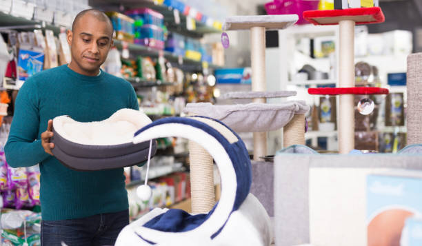 istock Man chooses accessories for cats in pet store 1301071062