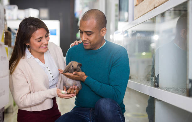 istock Happy couple holding rabbit in pet sho 1301071154