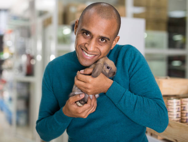 istock Portrait of man holding rabbit in hands 1301071179