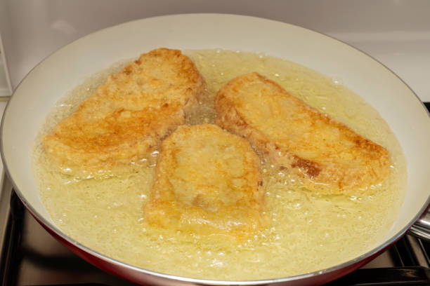 istock Pan with oil preparing fried bread with egg and flour (Torrijas). Typical Spanish Easter sweet. Traditional home cooking concept. Horizontal photography and selective focus 1301071252