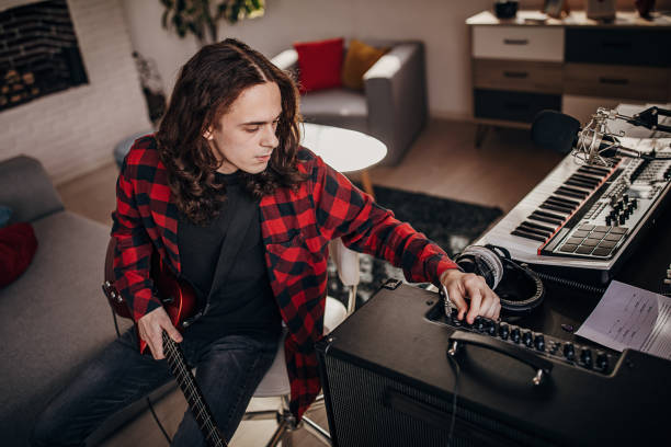 istock Male guitarist adjusting amplifier 1301071274