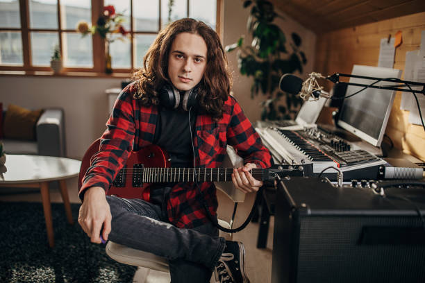 istock Male guitarist in home recording studio 1301071473