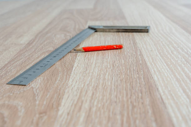 istock Red Carpenter's Pencil and Right Angle's Tool on Laminate Floor after Renovation or Reconstruction Work. DIY Project 1301072308