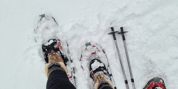 Snoeshoes and ski poles, top view, in deep snow.  Winter weather and winter snow sports ideas.