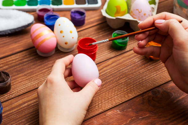 istock Mother and son are painting Easter eggs. Preparing decorations for Easter, creativity with children, traditional symbols. Preparing for Easter. 1301074838