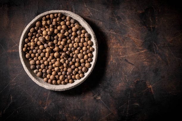 Allspice also Jamaica pepper dried berries on dark wood Allspice also Jamaica pepper dried berries on dark wood background, Pimenta dioica allspice stock pictures, royalty-free photos & images
