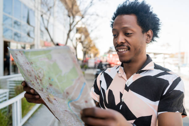 istock Tourist man looking for directions on map. 1301075786