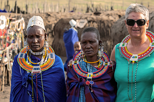 Serengeti, Tanzania - March 12, 2015: Masai with traditional ornaments and tourist review of daily life of local people on March 12, 2015 near Serengeti National Park.