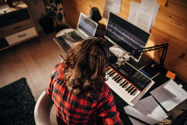 Male artist making music in recording studio One man, teenage male guitarist with long hair making music on electric guitar and singing in recording  studio at home. making music stock pictures, royalty-free photos & images