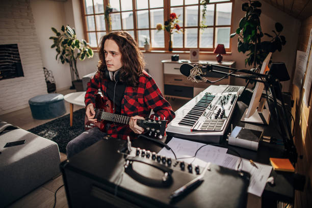 istock Male guitarist playing electric guitar in home studio 1301076402