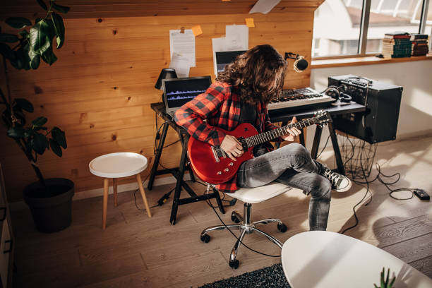 istock Male guitarist playing electric guitar in home studio 1301076454