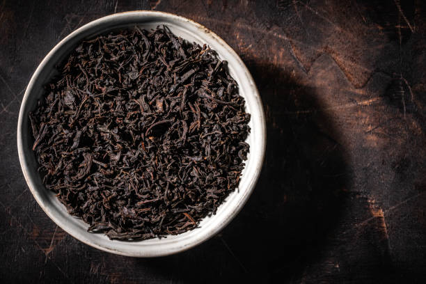 istock Black tea dried leaves on dark wood 1301076737