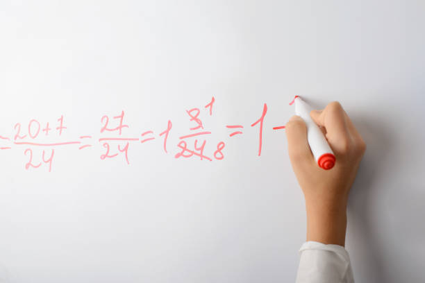 istock Hand of a school girl counting math equation on a whiteboard 1301078823