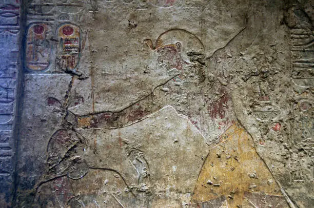 A carved and painted relief showing the Pharoah Ramses II about to behead a Nubian. Wall of the Temple of Beit al-Wali on the shores of Lake Nasser near Aswan, Egypt.