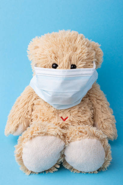 istock Teddy bear in a medical mask against blue background 1301080494