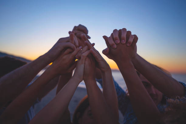 grupa ludzi trzymająca się za ręce w celebracji i przyjaźni. - human hand holding hands hands clasped group of people zdjęcia i obrazy z banku zdjęć