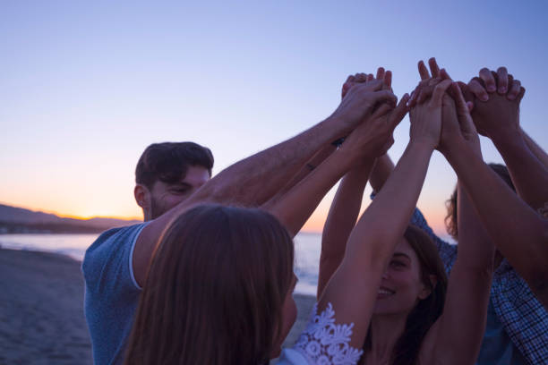 istock Group of people holding hands in celebration and friendship. 1301081605