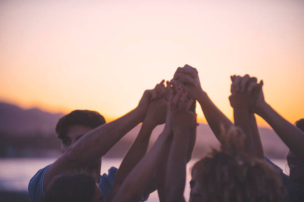 istock Group of people holding hands in celebration and friendship. 1301081620