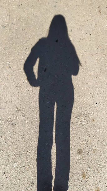 istock female silhouette on gray asphalt on a sunny day 1301084271