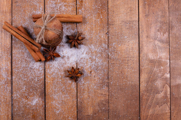istock distant top view of a stack of cookies tied with a rope, cinnamon sticks and decorative flowers, lie on white scattered powder, on a background of wooden boards 1301084335
