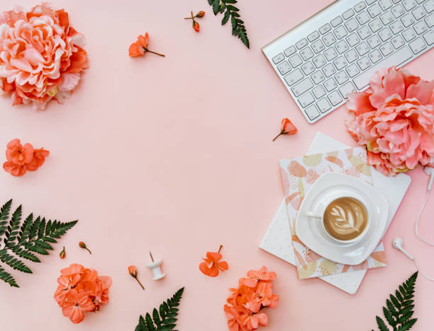 istock Top view Freelancer home office desk. Blogger workspace with coffee, keyboard, flowers and stationery on pink background 1301084891