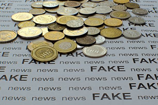 フェイクニュースの背景に異なる国のコイン - imitation currency paper currency gold ストックフォトと画像