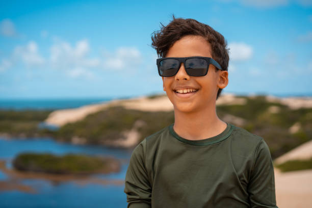 Boy wearing sunglasses on the dunes in Genipabu