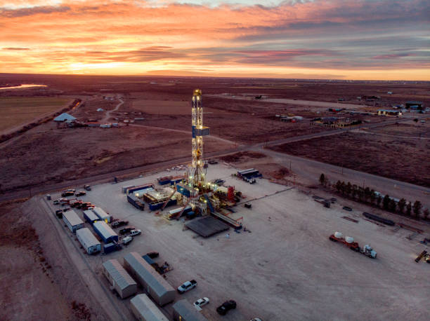 drone view of an oil or gas drill fracking rig as the sun sets in new mexico - oil industry industry new mexico oil drill imagens e fotografias de stock