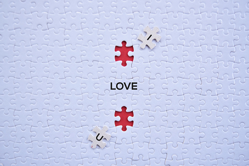 'I Love U' saperated word on white puzzles with red blank background top view concept.