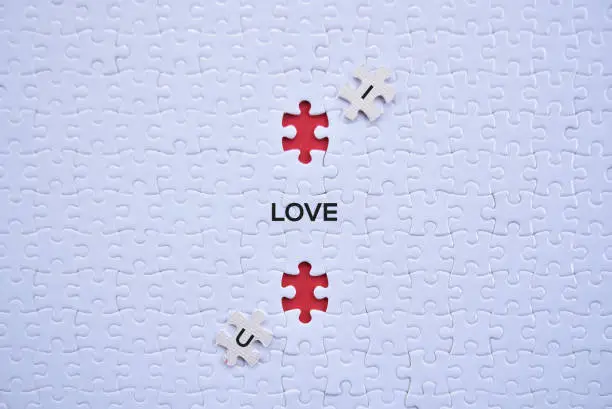 Photo of 'I Love U' saperated word on white puzzles top view concept.