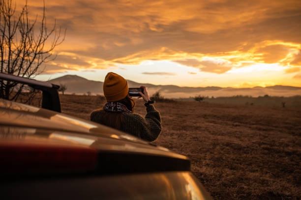 istock Young woman is photographing winter sunset 1301090538