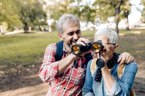 istock Mature man and woman exploring the nature with binoculars and having fun 1301090595