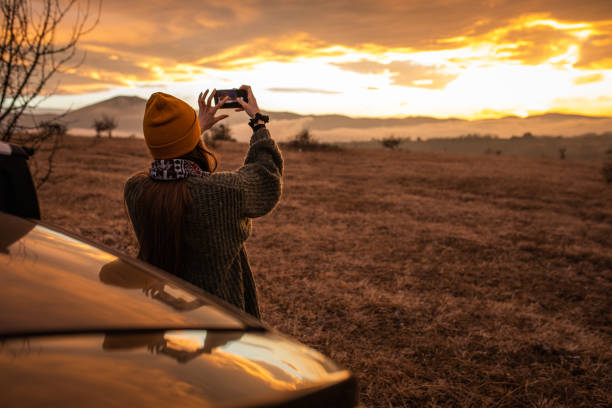 istock Young woman is photographing winter sunset 1301091146