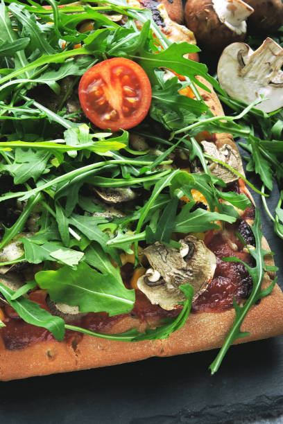 Vegan pizza with mushrooms and fresh arugula.