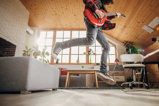 istock Male guitarist playing electric guitar while jumping 1301092412