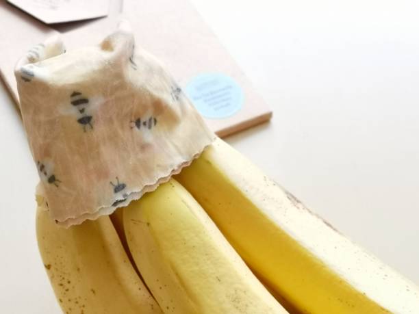 Use of beeswax cloth as alternative to traditional plastic Wrap in Order to keep bananas fresh Mobile Shot beeswax cloth banana freshness beeswax wrap stock pictures, royalty-free photos & images