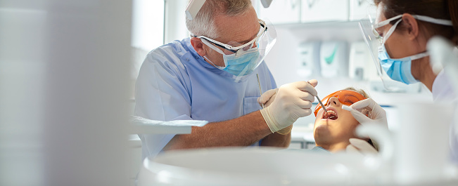 Vertical photo of dentist doing preventive examination to a man