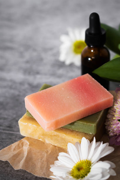 istock Green, rose and yellow soaps with a fresh flowers in a romantic setting. Spa wellness concept 1301093863