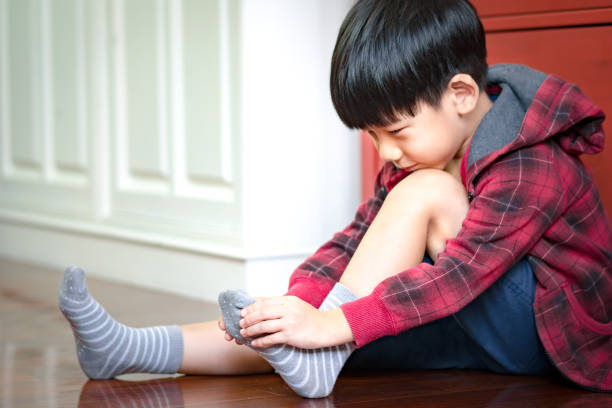 istock Cute Asian boy getting dressed for school, putting on socks, smiling with happiness to go back to school 1301102908