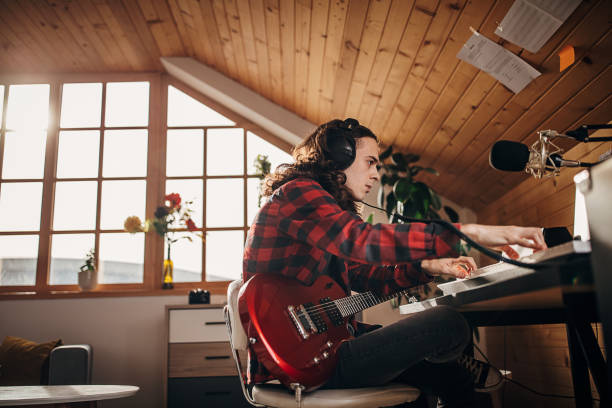 Male artist making music in home recording studio
