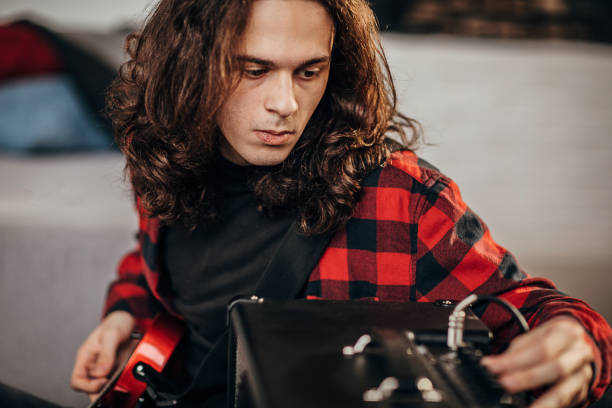 istock Male guitarist adjusting amplifier 1301103766