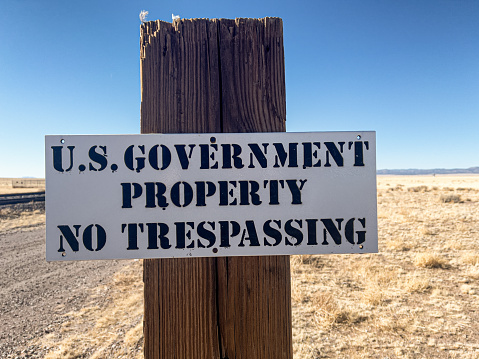Remote desert location with post and sign that states US Government Property No Trespassing