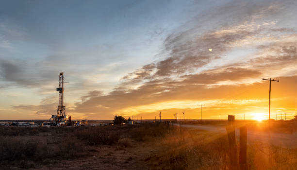 plate-forme de fracturation de forage de pétrole pendant que le soleil se couche à l’arrière-plan, nouveau mexique - oil industry industry new mexico oil drill photos et images de collection