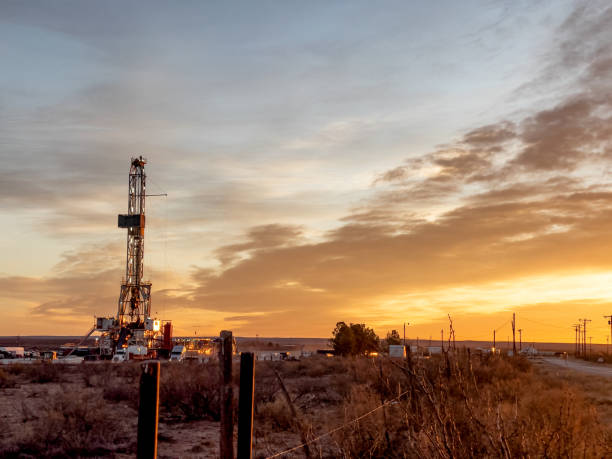 plate-forme de fracturation de forage de pétrole ou de gaz pendant que le soleil se couche à l’arrière-plan, nouveau mexique - oil industry industry new mexico oil drill photos et images de collection