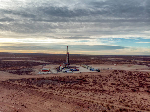 oil or gas drill fracking rig pad as the sun sets in the background, new mexico - oil industry industry new mexico oil drill fotografías e imágenes de stock