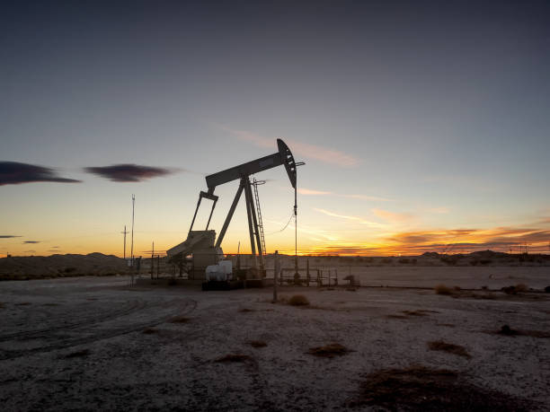pump jack in new mexico with the beautiful sunset in the background - sunset petroleum silhouette new mexico imagens e fotografias de stock