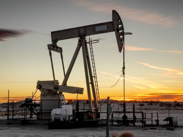 pump jack in new mexico with the beautiful sunset in the background - sunset petroleum silhouette new mexico imagens e fotografias de stock