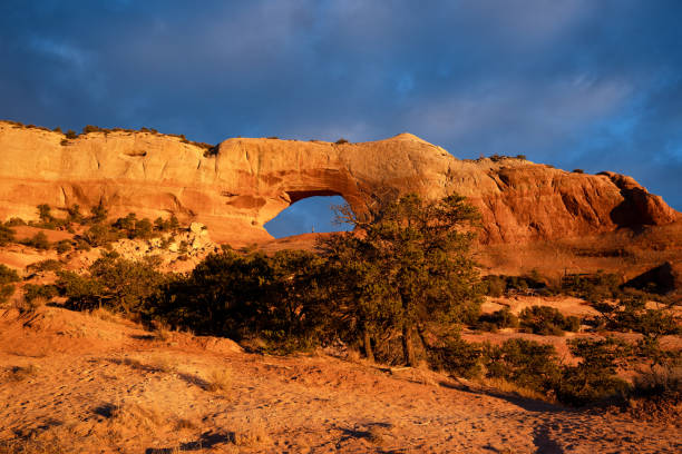 impresionante vista del arco de wilson cerca de moab, utah con la puesta de sol y las oscuras nubes de invierno en el fondo - extreme terrain eroded snow landscape fotografías e imágenes de stock